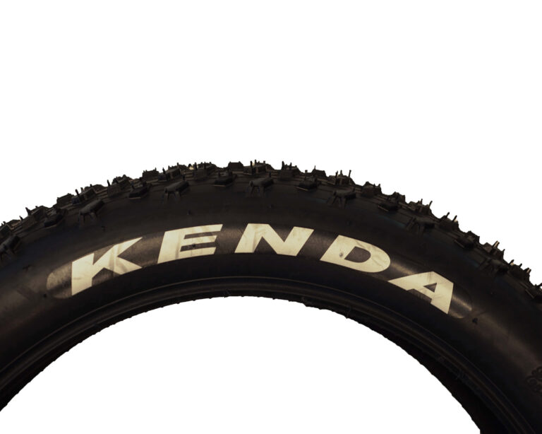 Detailansicht des Reifenprofils des E-Bike-Zubehör, Ersatzteil für die Cruiser-E-Bikes von MC E-Bike, schwarze Fatbike-Reifen mit groben Stollen mit weißem Kenda-Schriftzug in der Größe 20 Zoll mal 4.0